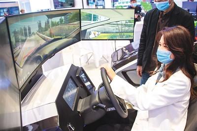 11月19日，参观者在“5G+工业互联网成果展”上体验驾驶智能模拟器。伍志尊摄(新华社发)